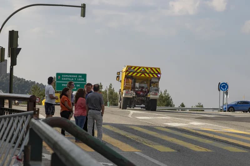 A city street under a hazy sky as people shelter in shade during an extreme heat warning