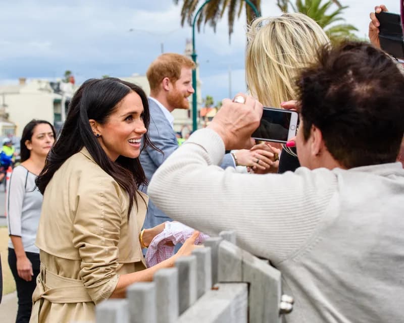 Prince Harry and Meghan, the Duke and Duchess of Sussex, walking together at a public engagement